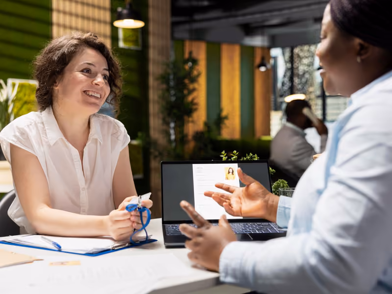 Service business professional consulting with a client at a desk with a laptop