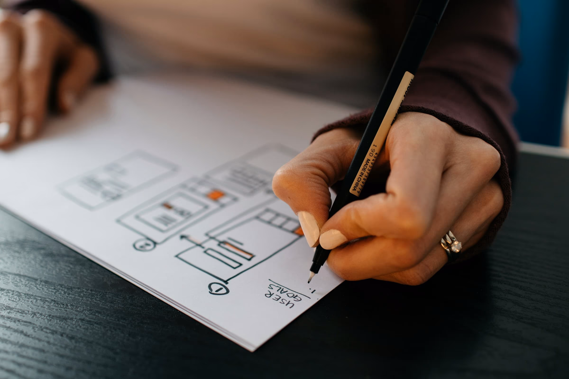Person reviewing and planning a website redesign on paper, preparing to improve an existing site
